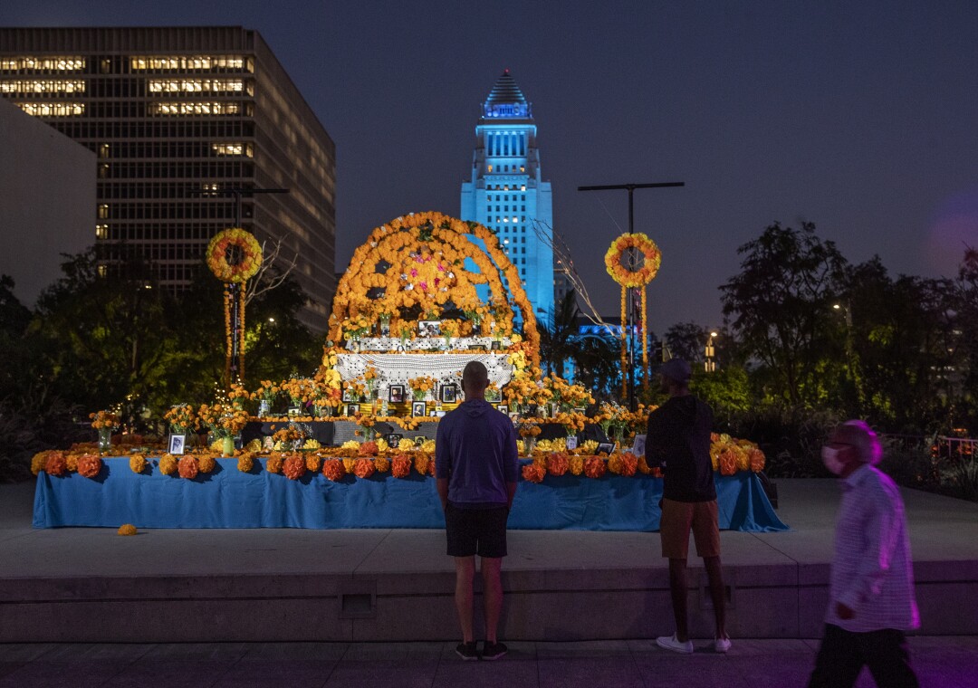 El Altar del Día de los Muertos en Grand Park, con el Ayuntamiento, iluminado en azul, detrás de él.