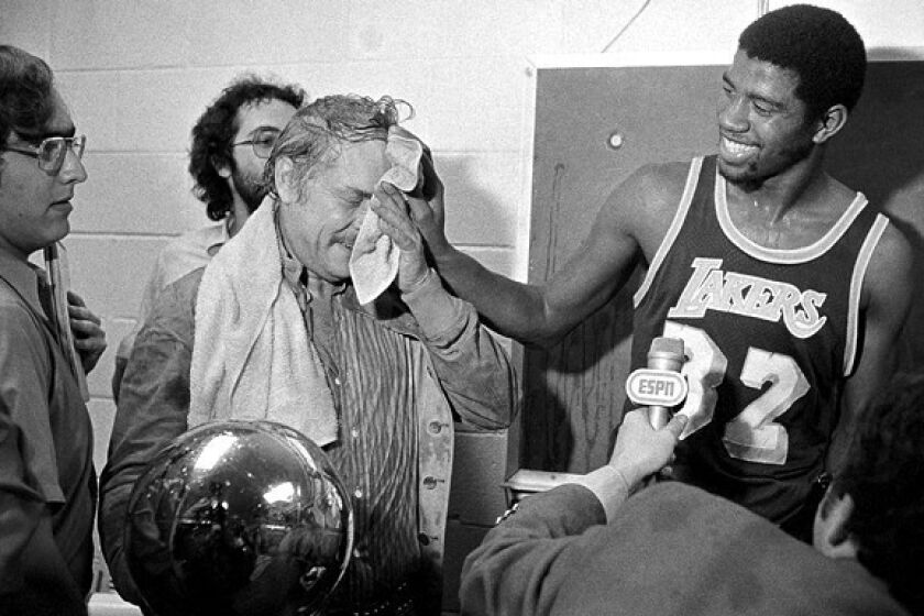 Rookie Magic Johnson wipes the face of owner Jerry Buss after pouring champagne over him during the Lakers' celebration for winning the 1979-80 NBA championship.