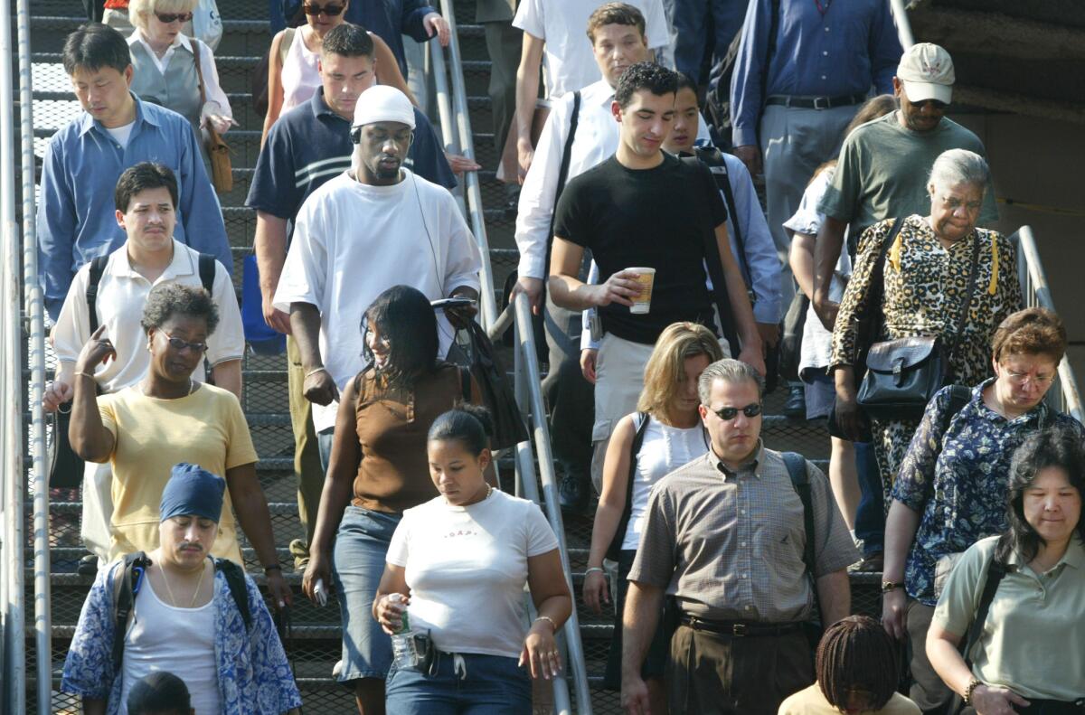 Commuters descend steps from the Staten Island Ferry on their way to work in New York City.