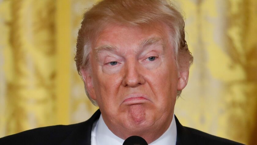 A closeup of President Trump frowning.