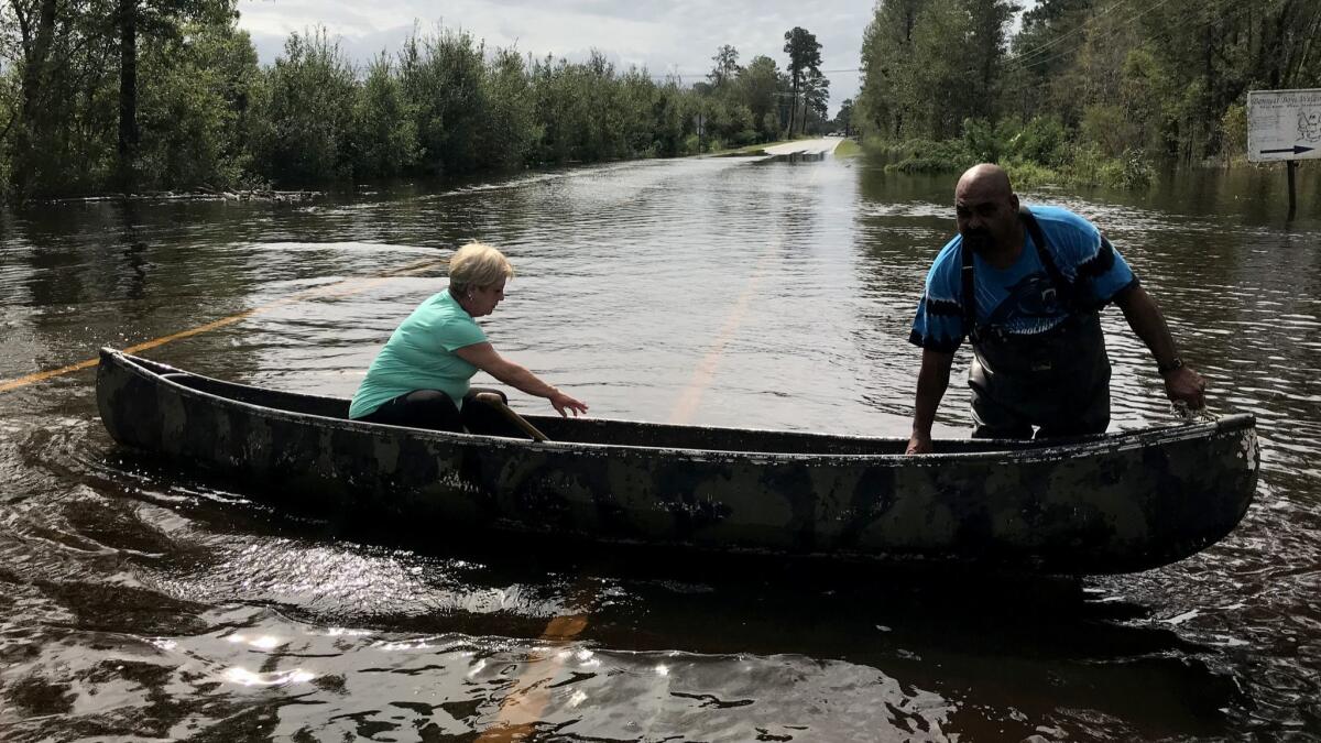 James Lewis used his canoe to take Renee Bennett to check on her Lumberton, N.C., home that was on the verge of flooding Monday morning.