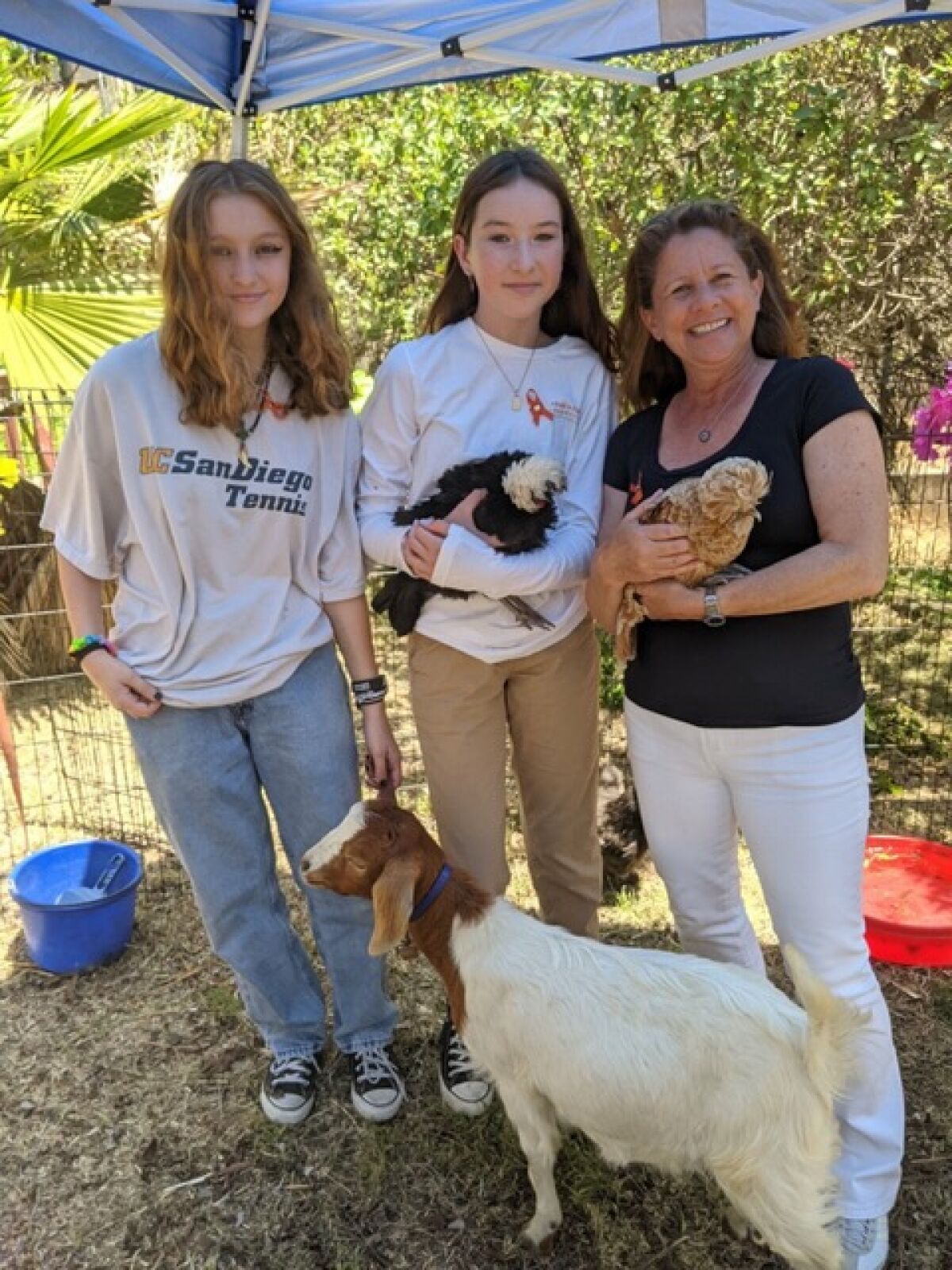 Adopt a Family co-founder and CEO Carine Chitayat with two young guests enjoying Pam’s Petting Zoo.