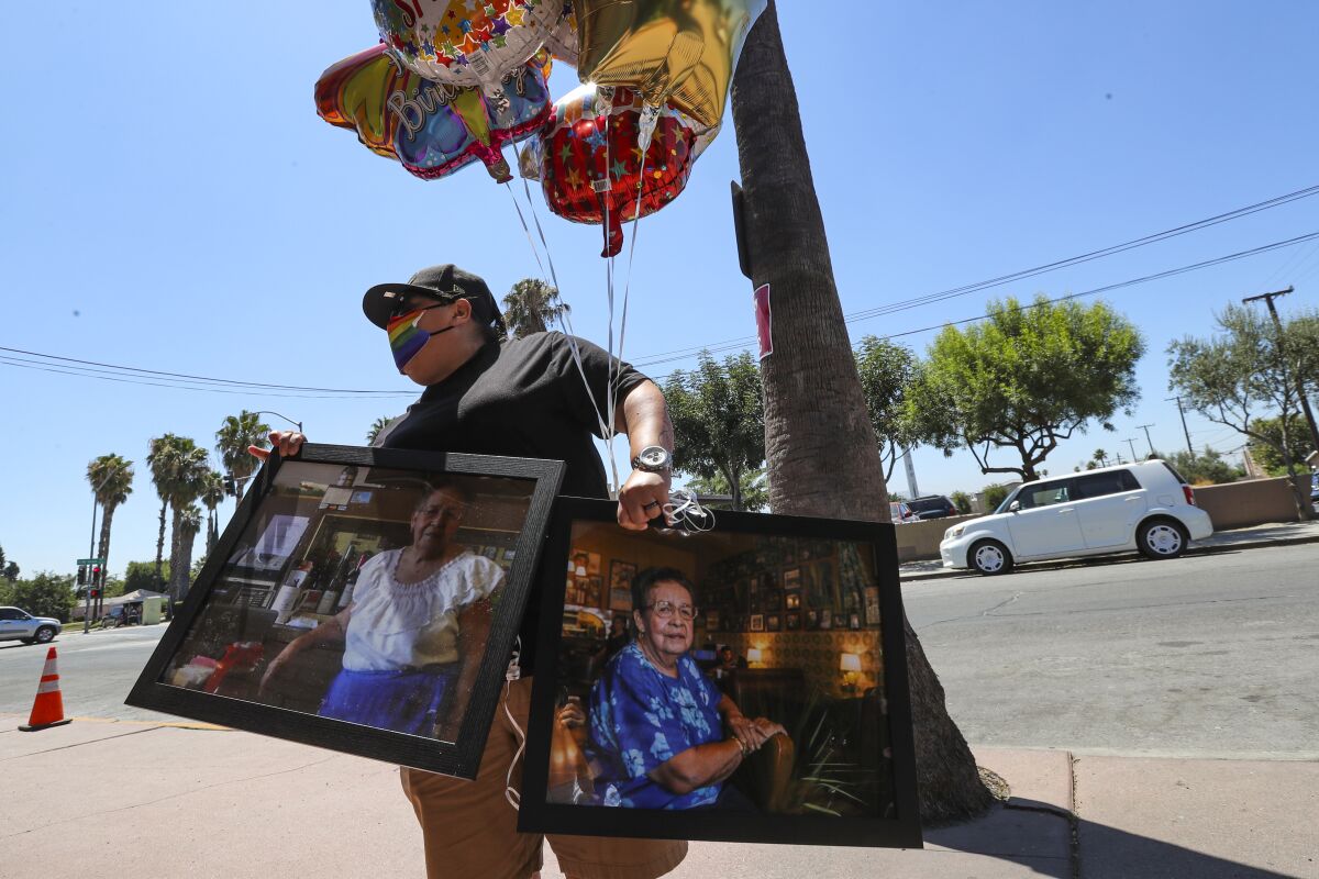 Denise Vara brings balloons and photos of Lucy Reyes for her memorial service outside Mitla Cafe in San Bernardino.