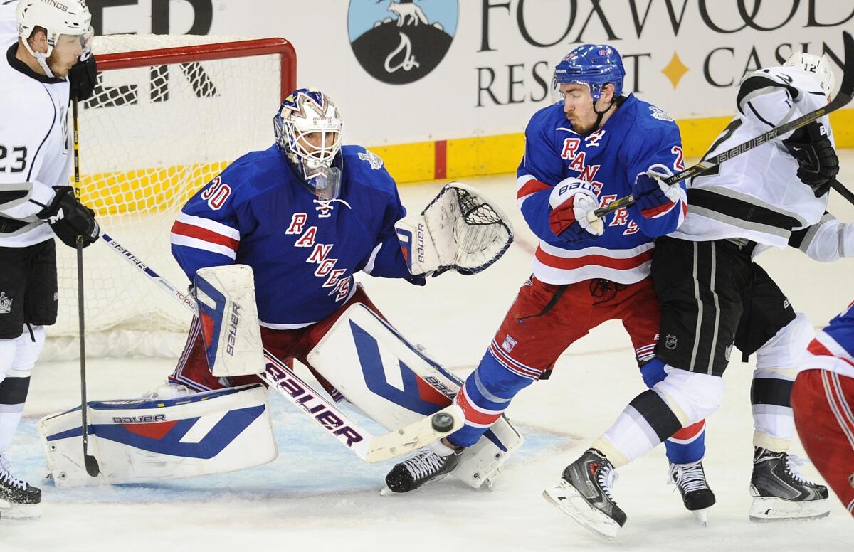 New York Rangers goalie Henrik Lundqvist makes a save in front of defenseman Ryan McDonagh, second right, as Kings teammates Dustin Brown, left, and Marian Gaborik try to get to the puck during the third period of Game 4 of the Stanley Cup Final.
