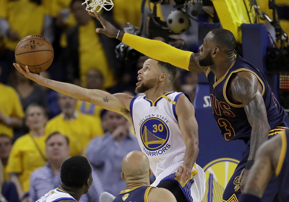 ARCHIVO - Foto del 1 de junio de 2017, en la que Stephen Curry (30) de los Warriors de Golden State dispara al aro sobre LeBron James de los Cavaliers de Cleveland.
