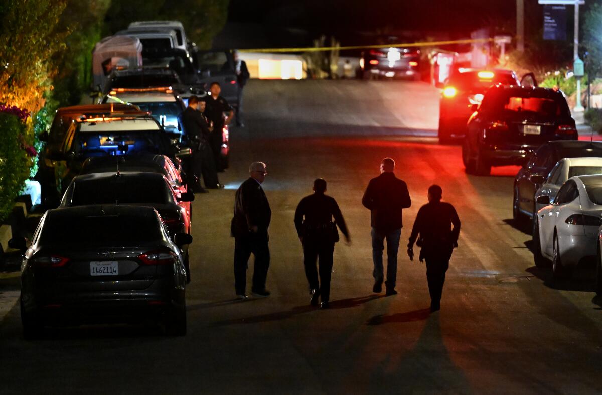 Police investigators walk along the street where Matthew Perry's house is in Pacific Palisades.