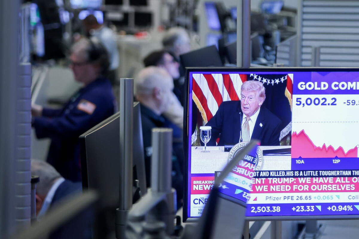 A television station broadcasts President Trump on the floor of the New York Stock Exchange.