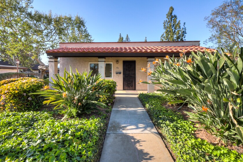 A home with a tile roof and pillars in front. 