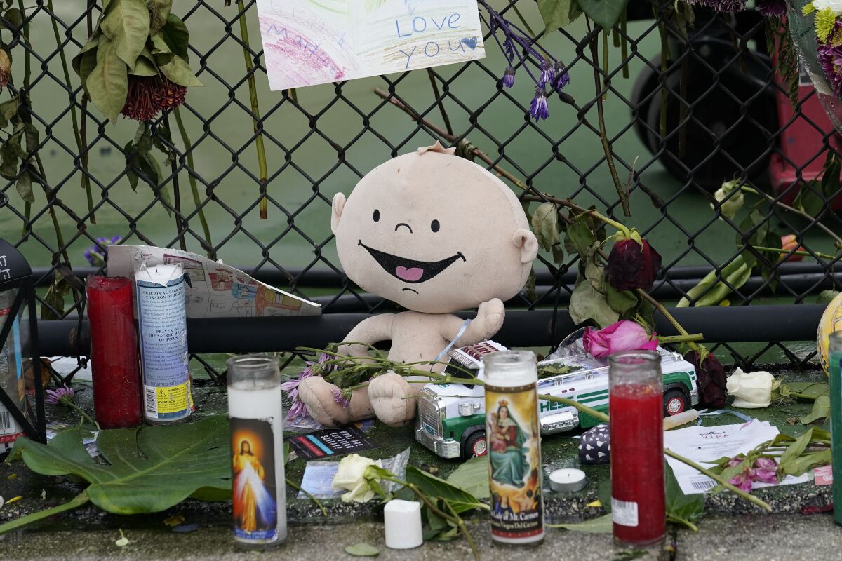 Items are seen at a make-shift memorial outside St. Joseph Catholic Church near the Champlain Towers South condo, Tuesday, June 29, 2021, in Surfside, Fla. Many people were still unaccounted for after Thursday's fatal collapse. (AP Photo/Gerald Herbert)