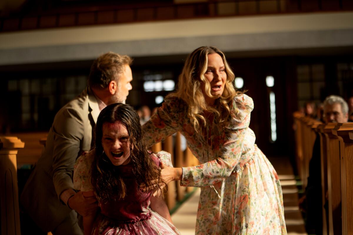 Parents and their daughter crying in a church