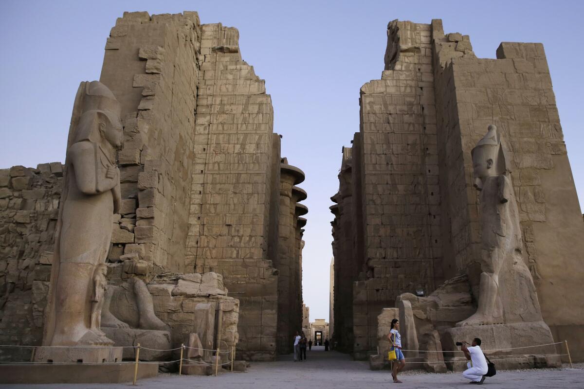 En esta imagen de archivo del domingo 30 de noviembre de 2014, una turista posa para una foto en el templo de Karnak, en Luxor, Egipto. Un atacante suicida se hizo explotar el miércoles en el antiguo templo de Karnak en Luxor, según fuentes egipcias. Luxor, al sur del país, es visitada cada año por millones de turistas egipcios y extranjeros. (AP Fhoto/Hassan Ammar, Archivo)