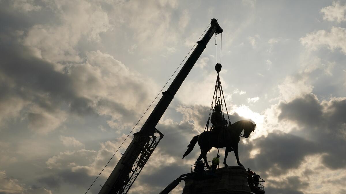 Crews work to remove one of the country's largest remaining monuments to the Confederacy, a towering statue of Confederate Gen. Robert E. Lee on Monument Avenue, Wednesday, Sept. 8, 2021, in Richmond, Va. (AP Photo/Steve Helber, Pool)
