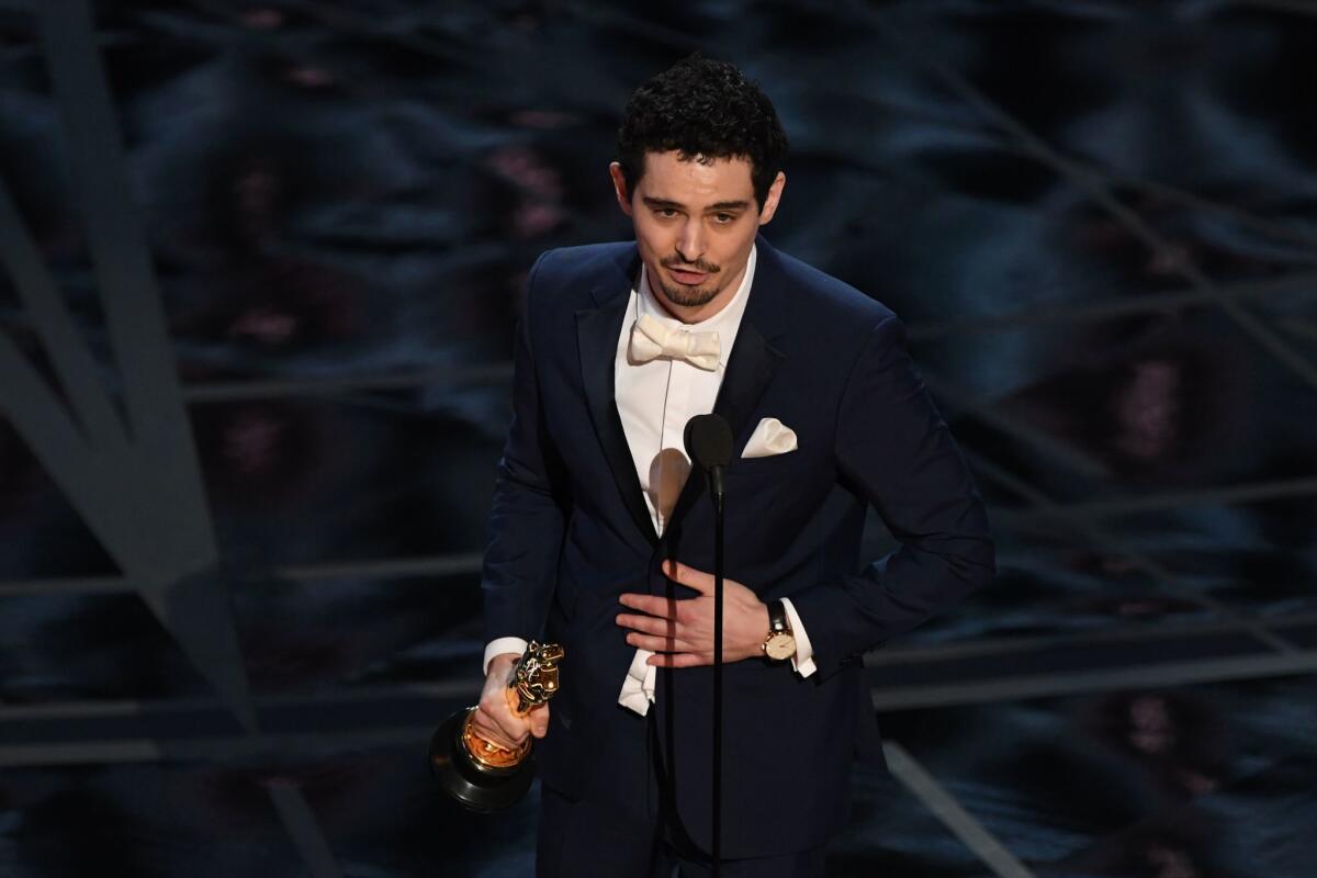 Director Damien Chazelle delivers a speech on stage after he won the Oscar for directing "La La Land."