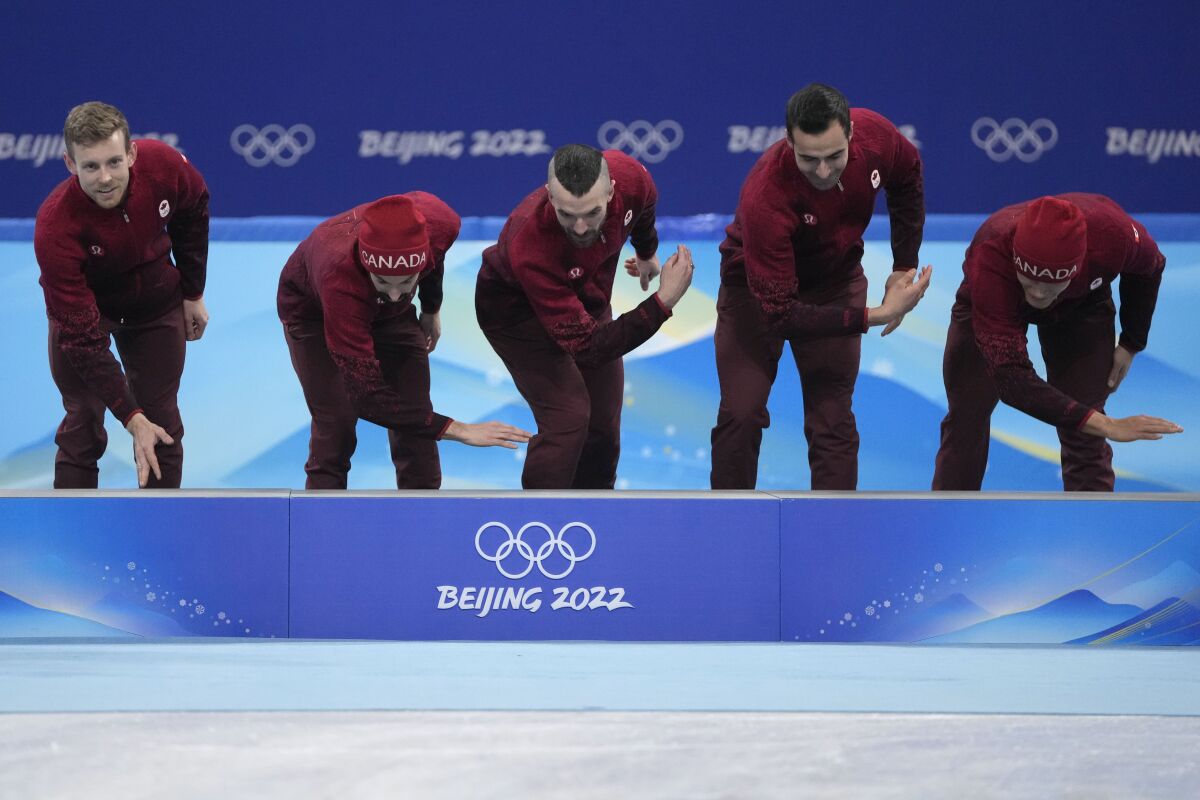 Team Canada celebrate during the victory ceremony after winning the men's 5000-meters relay final during the short track speedskating competition at the 2022 Winter Olympics, Wednesday, Feb. 16, 2022, in Beijing. (AP Photo/Natacha Pisarenko)