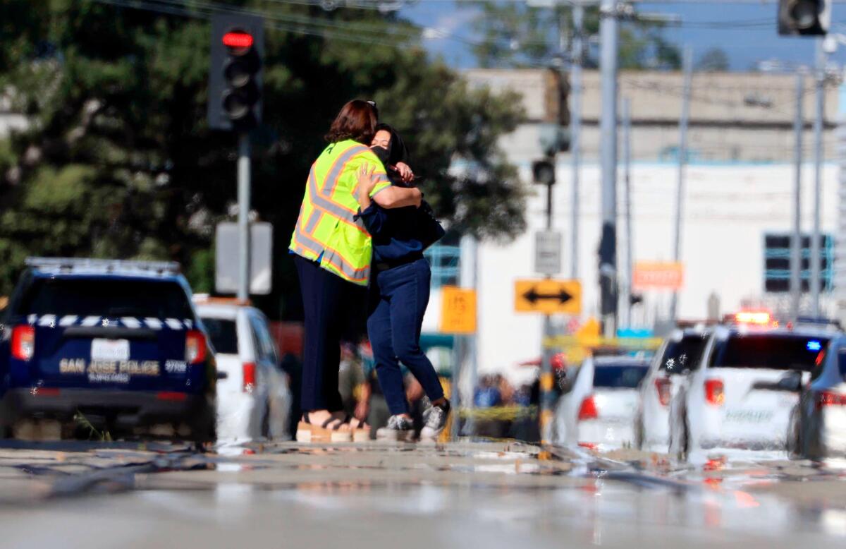 Two people hug outside the scene of a shooting in San Jose, Calif., on Wednesday, May, 26. 2021. 