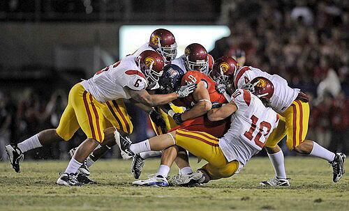 Arizona's Ron Gronkowski is brought down by a host of USC defenders during the first half Saturday.