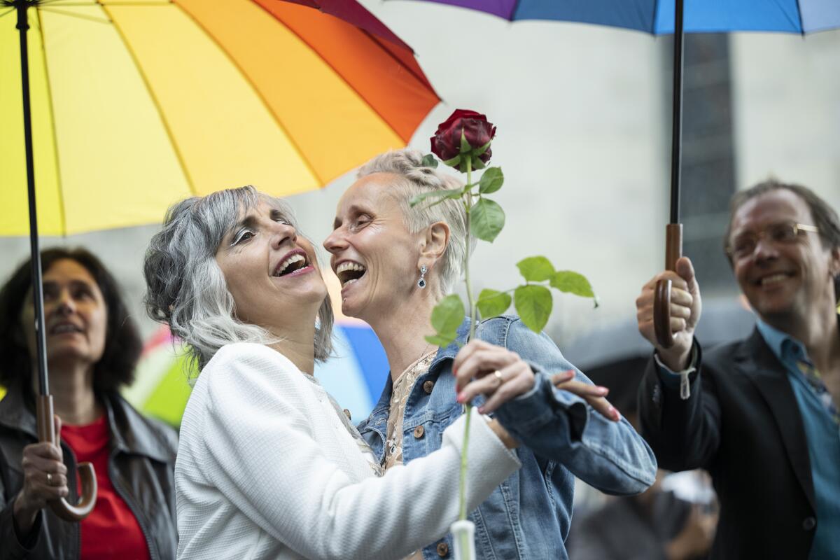 Annett Babinsky, right, and Laura Suarez celebrate their marriage at the registry office 'Amtshaus' in Zurich, Switzerland, Friday, July 1, 2022. After a yes vote in the "Marriage for All" vote last fall, from July 1, same-sex couples marriage for the first time in Switzerland. (Ennio Leanza/Keystone via AP)