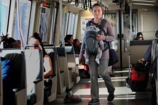 Panhandler with her baby on the BART train heading to the West Oakland station seen on Tuesday, Oct. 22, 2019, in Oakland, Calif.