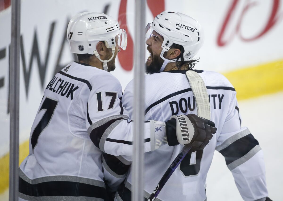 Drew Doughty, right, celebrates his game-winning goal against the Calgary Flames with Kings teammate Ilya Kovalchuk.