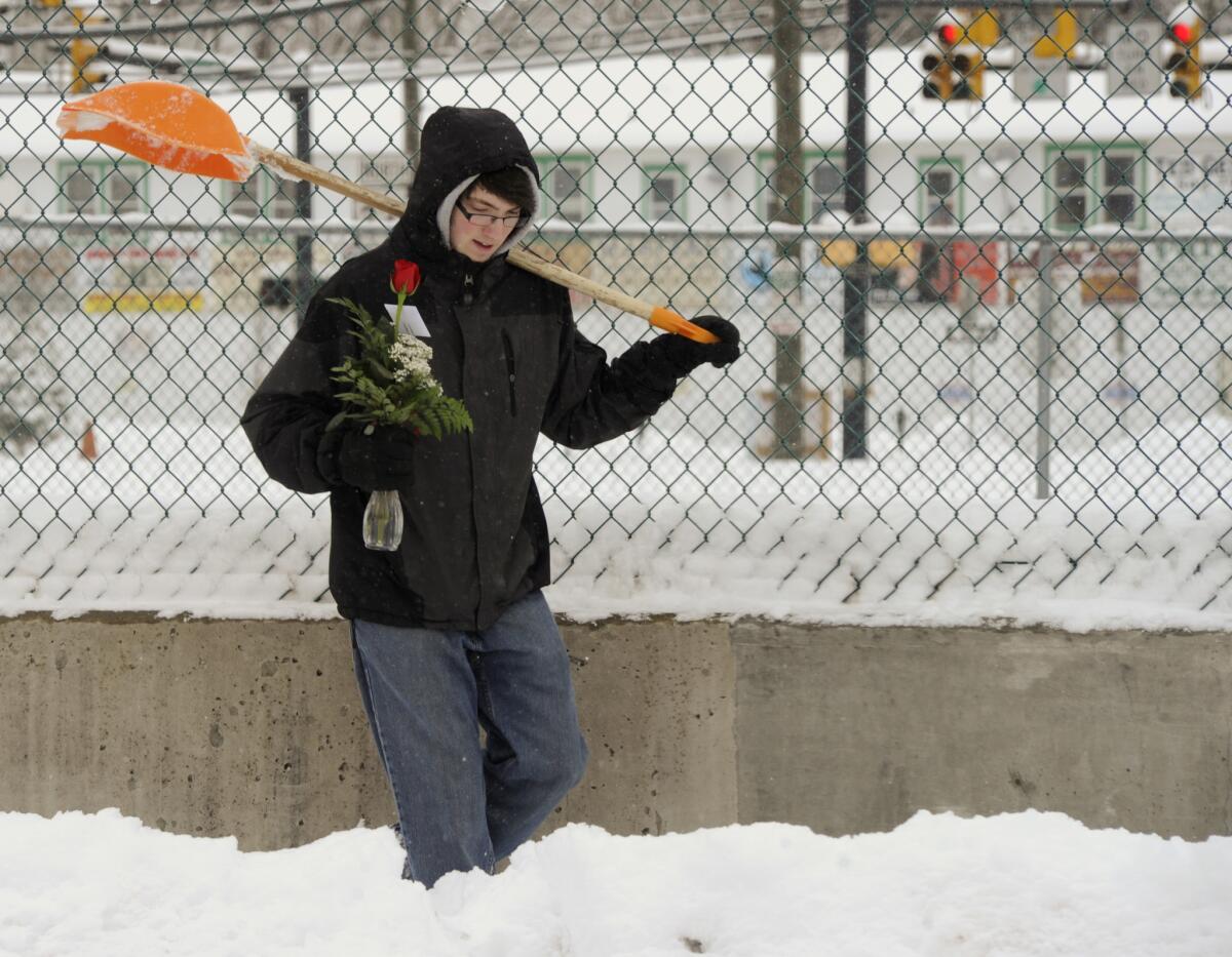 In Shickshinny, Pa., Joshua Hess - after helping his employer shovel out Thursday - heads home with a rose that he bought his girlfriend for Valentine's Day and her birthday, which fall on the same day.