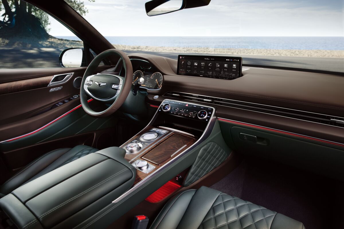 Cabin width was emphasized through the thin air vents that run across the passenger compartment. Soft materials cover every surface, from the inside of the door handles to the quilted knee pads that line the lower sides of the console.