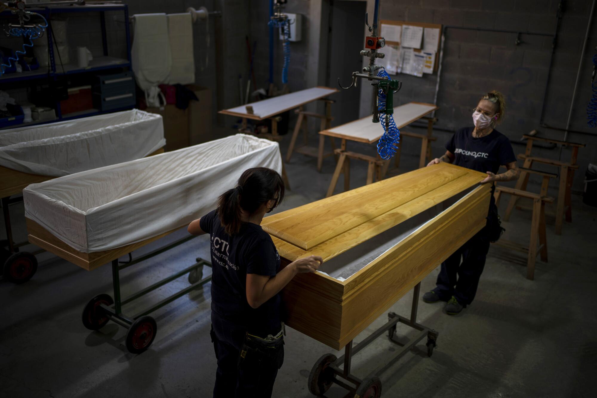 Employees work on coffins at the Eurocoffin factory in Barcelona, Spain.
