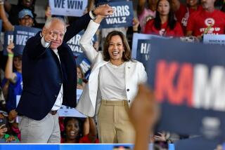 ROMULUS, MICHIGAN - AUGUST 7: Vice Presidential nominee Tim Walz raises the hand of Presidential nominee Kamala Harris as she takes the stage to speak to several thousand attendees at her presidential campaign rally at Detroit Metropolitan Wayne County Airport in Romulus, MI on August 7, 2024. (Photo by Adam J. Dewey/Anadolu via Getty Images)