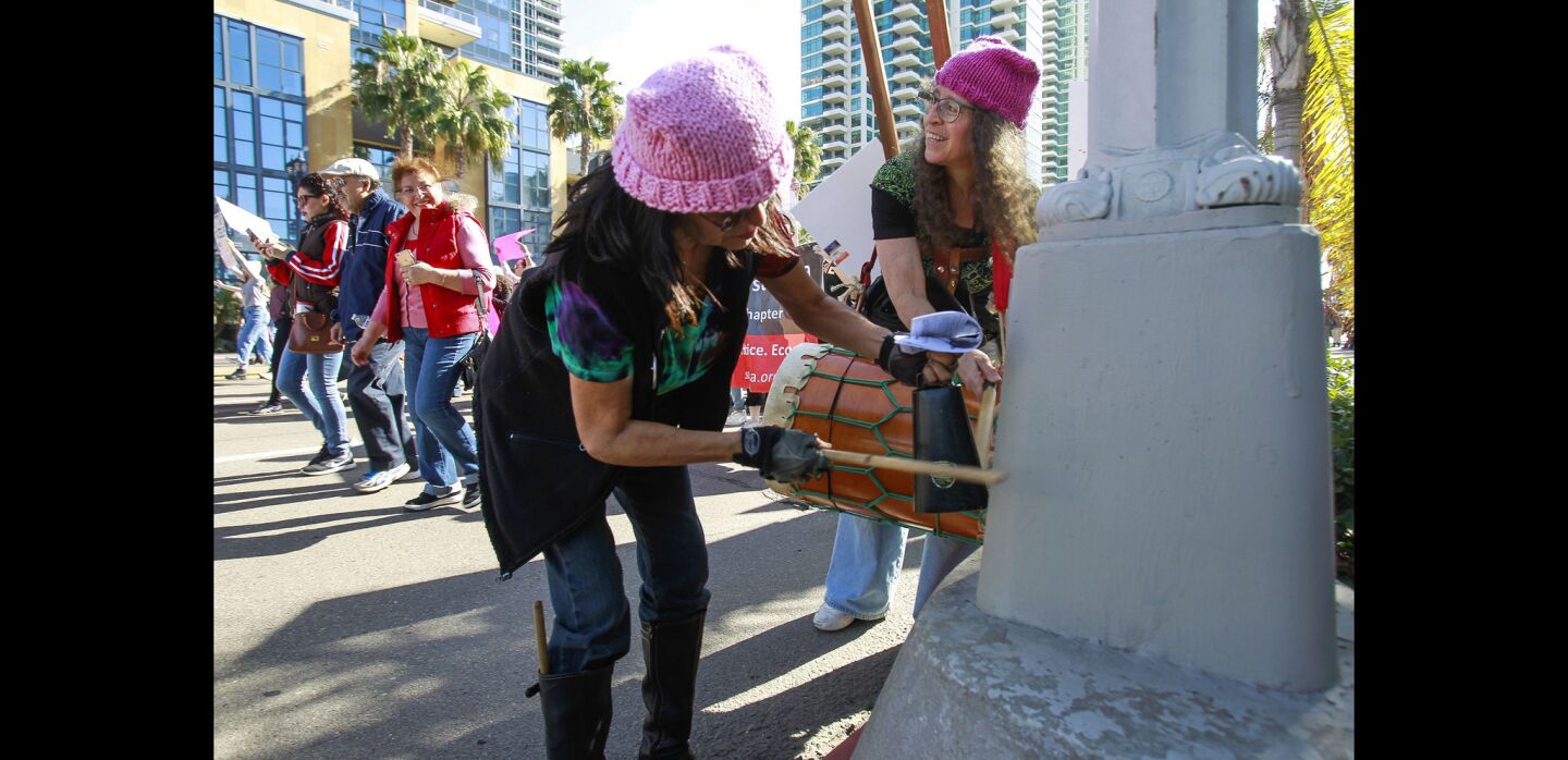 Louise Blue, left, and Lisa Tansey drum on a light pole during the San Diego Women's March.