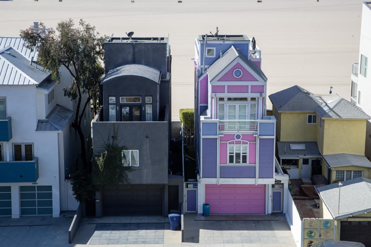 the Barbie House, pink and purple, right, and the all-black house right next to it, left.