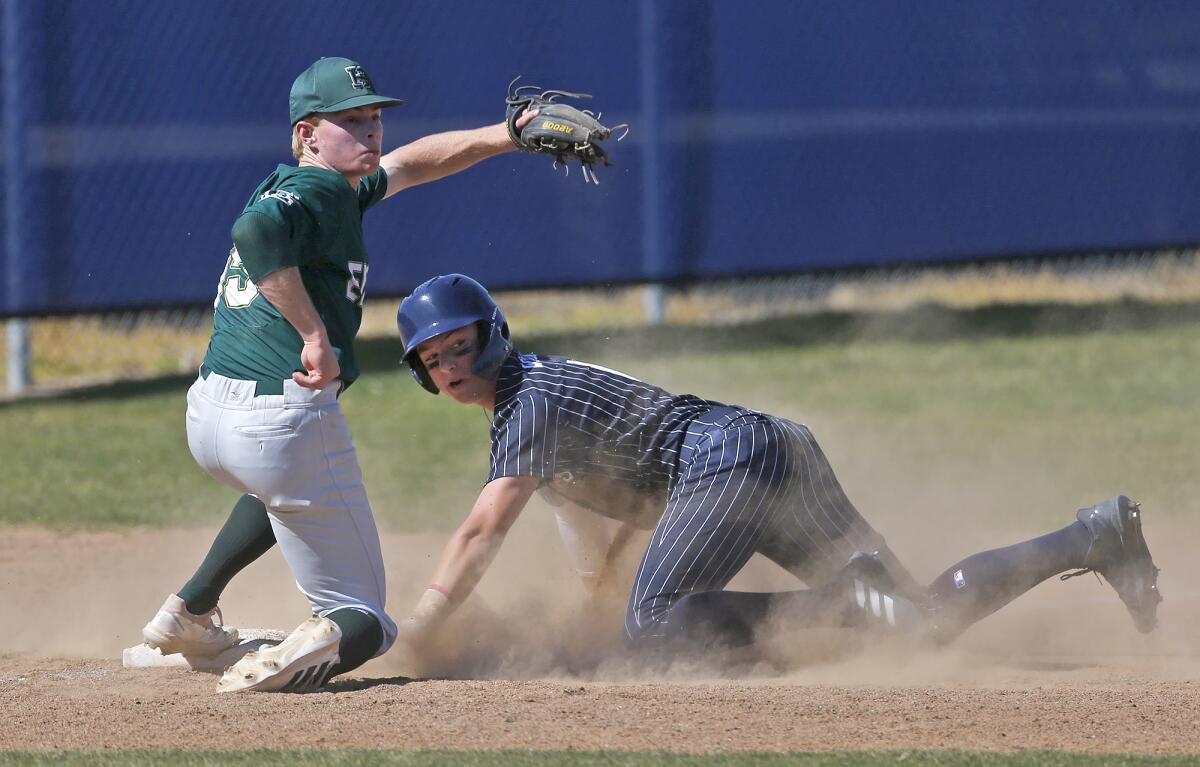 Newport Harbor's Ryan Williams slides into third base under the tag of Edison's Noah Stockman on Friday.