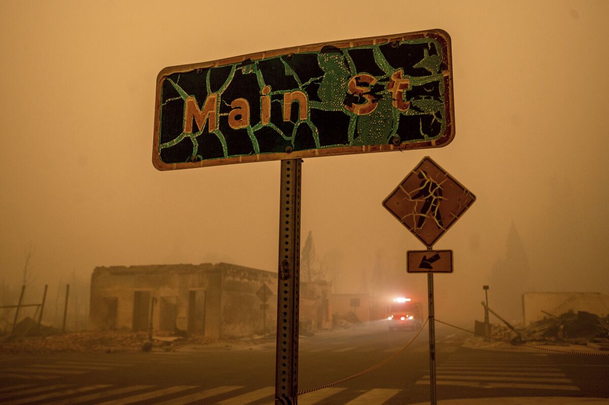 A fire truck drives through central Greenville, which was largely leveled by the Dixie Fire, Friday, Aug. 6, 2021, in Plumas County, Calif. (AP Photo/Noah Berger)