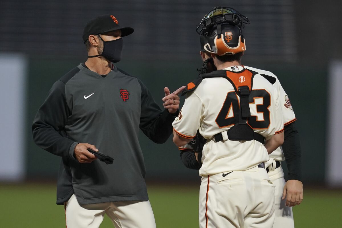 San Francisco Giants manager Gabe Kapler, left, talks with catcher Tyler Heineman (43) and pitcher Caleb Baragar during the fifth inning of a baseball game against the San Diego Padres in San Francisco, Thursday, July 30, 2020. (AP Photo/Jeff Chiu)