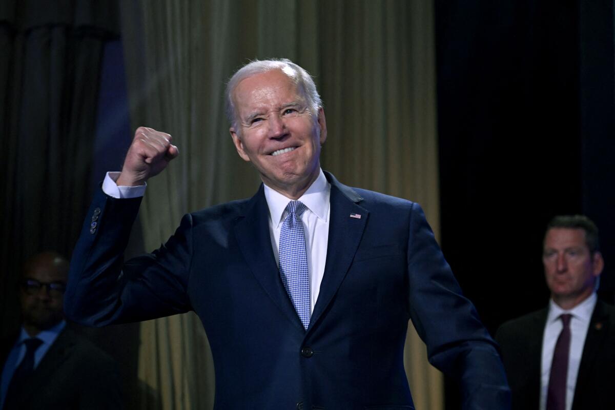 Joe Biden pumps his fist on a stage.