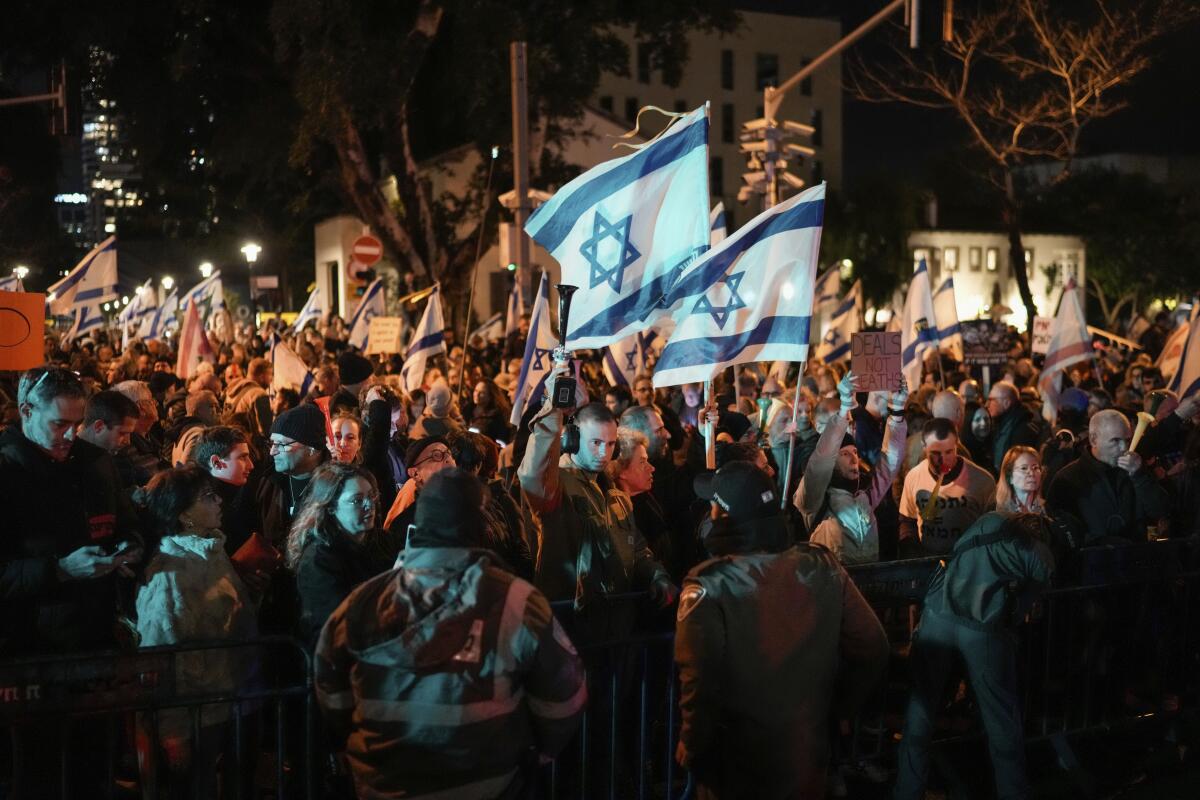 Demonstrators protest at night against Israeli Prime Minister Benjamin Netanyahu.