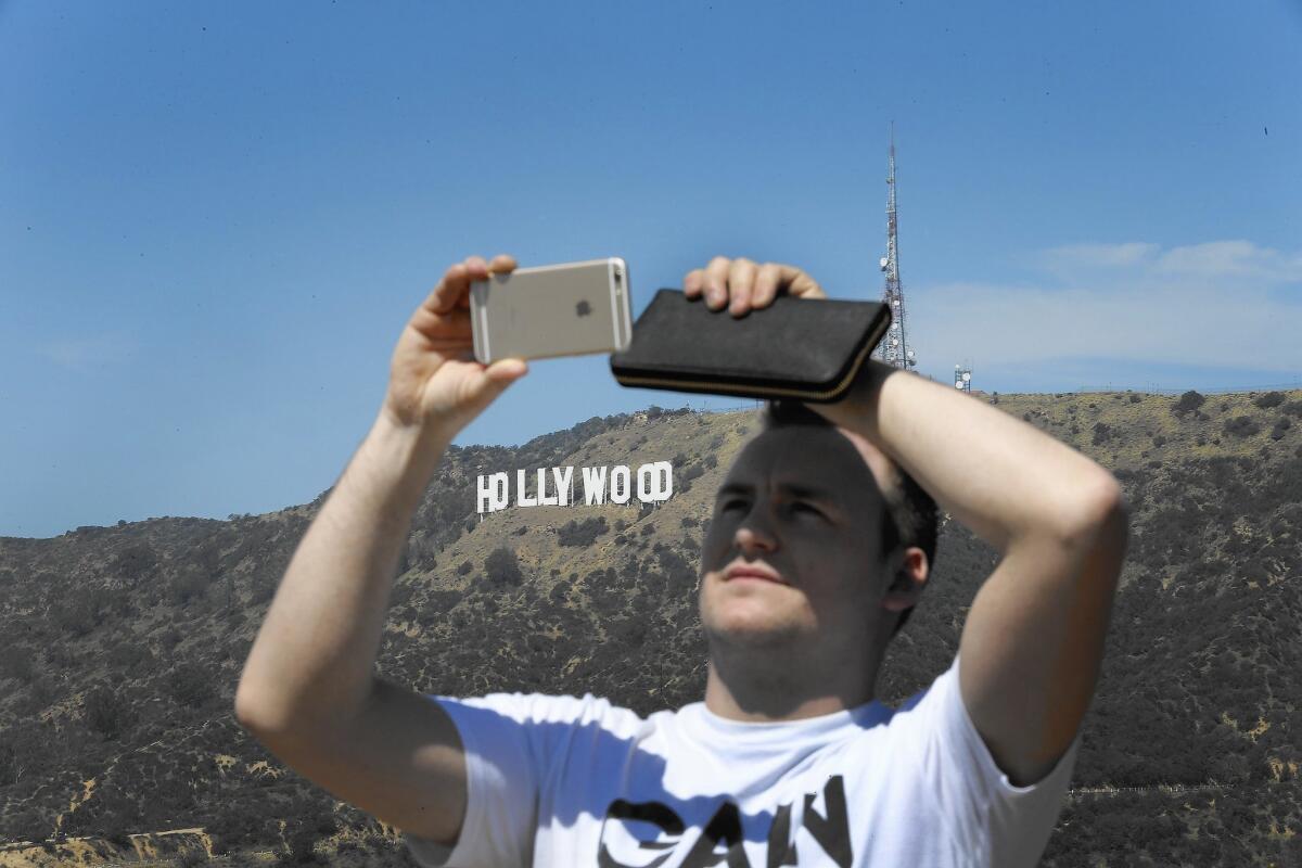 Robin Seimar of Sweden snaps a photo with the Hollywood sign in the background.