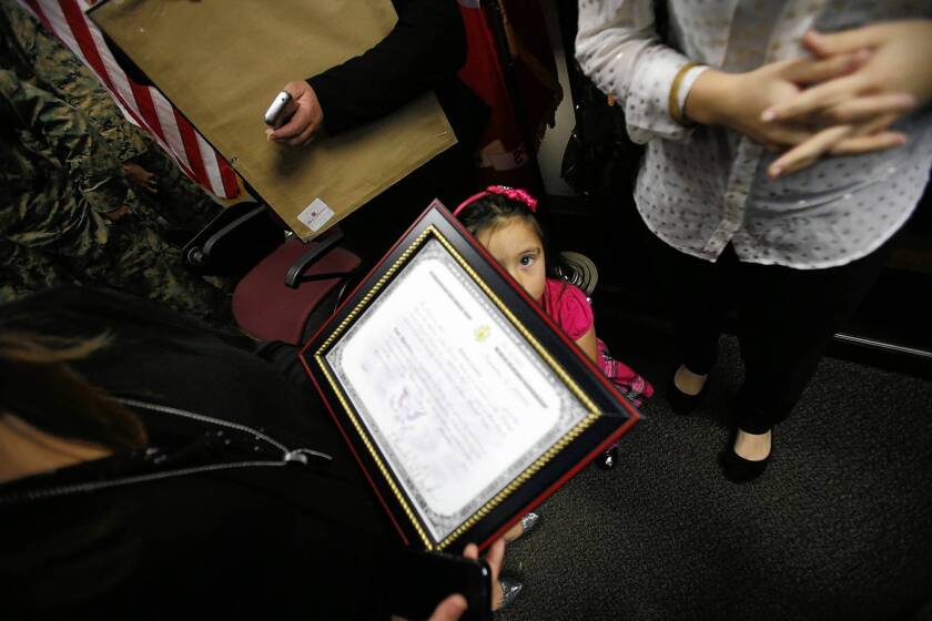 Ayleen Cazares, 4, the sister of Marine Cpl. Roberto Cazarez, looks at his certificate of U.S. citizenship at Camp Pendleton. It was awarded posthumously after he was killed serving in Afghanistan.