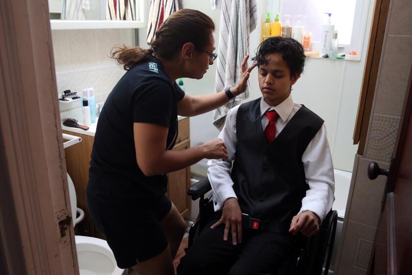 Herlinda Annicks styles her son Jonathan's hair at their home in Chicago as he gets ready for his senior prom on June 3, 2016. Weeks earlier, he was shot and paralyzed outside his home. He was able to return to school and attend the prom he had been anticipating for months.