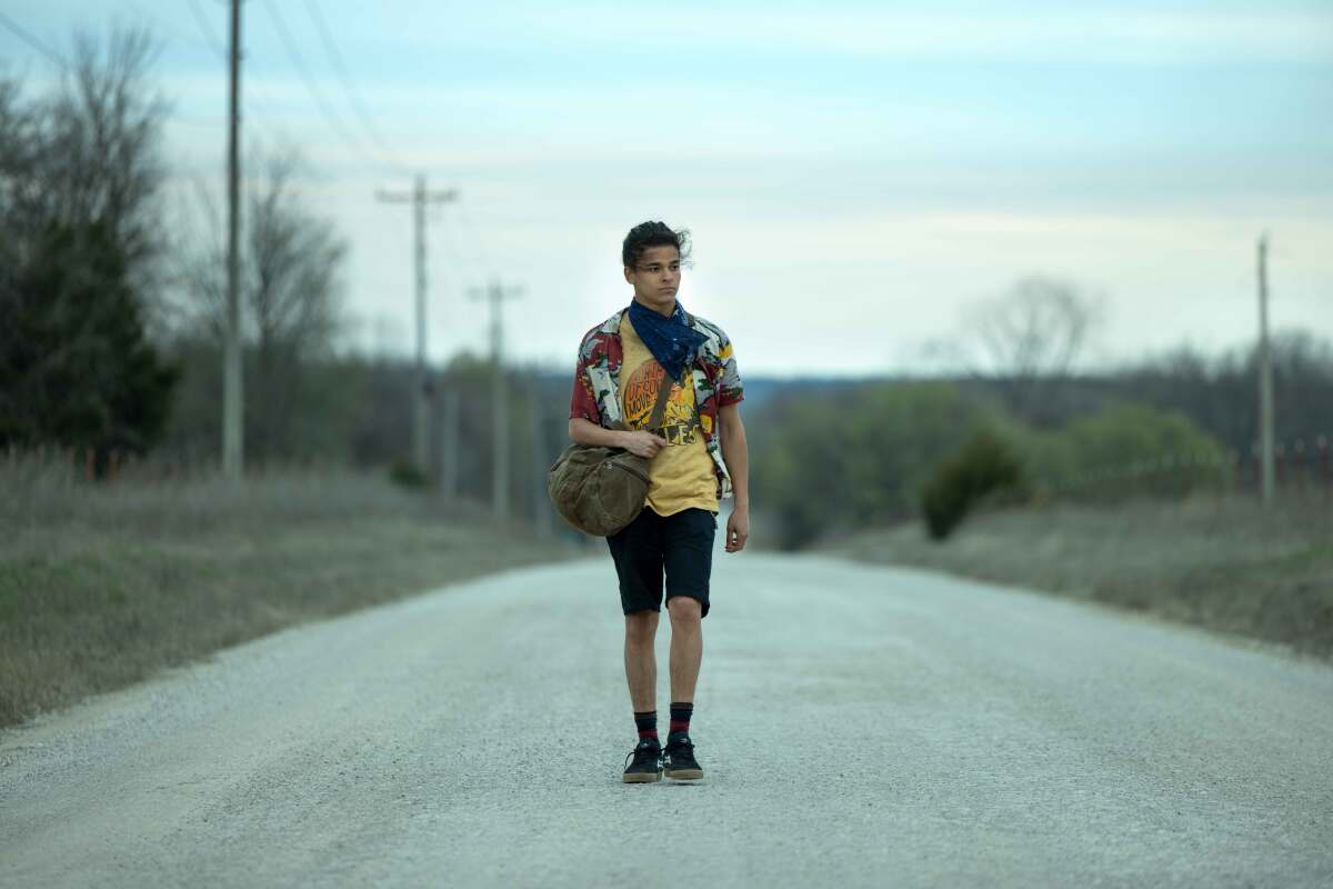 A teenage boy on a rural road.