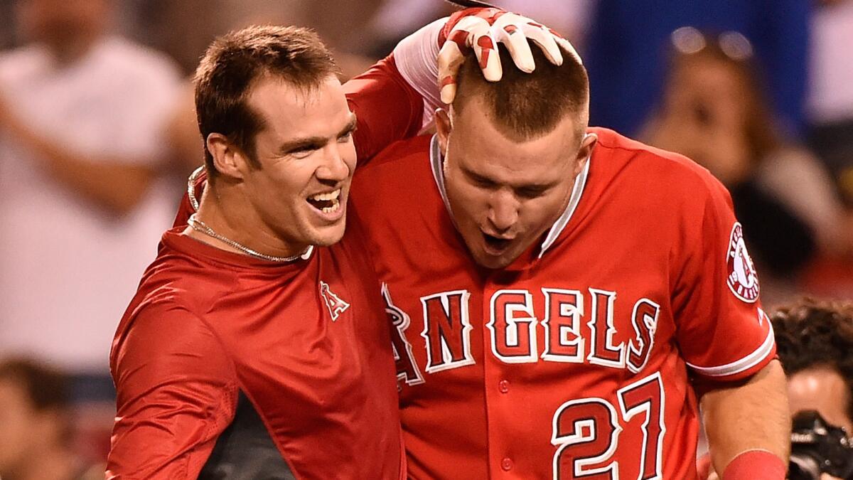 Angels right fielder Collin Cowgill, left, celebrates with teammate Mike Trout after hitting a home run in the 14th inning to lift the Angels to a 2-1 win over the Oakland Athletics on Tuesday.
