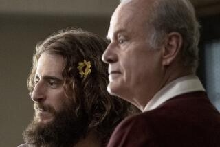 A young man with a beard and a flower in his hair with an older man in the movie "Jesus Revolution."