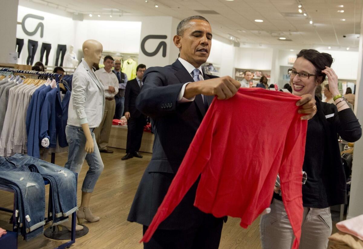 President Obama shops for clothing for his family alongside store employee Susan Panariello during a visit to a Gap clothing store in New York City to highlight his proposal to raise the federal minimum wage.