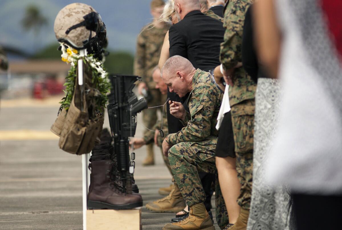 This Jan. 22, 2016, file photo shows family, friends and comrades paying respects during a memorial service in Hawaii for 12 Marines who died when their helicopters crashed off the North Shore of Oahu.