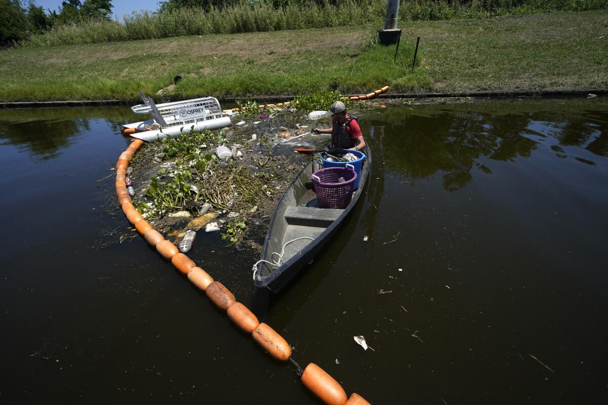 Jack Bates, de la Osprey Initiative, recoge en un río de Nueva Orleáns basura atrapada