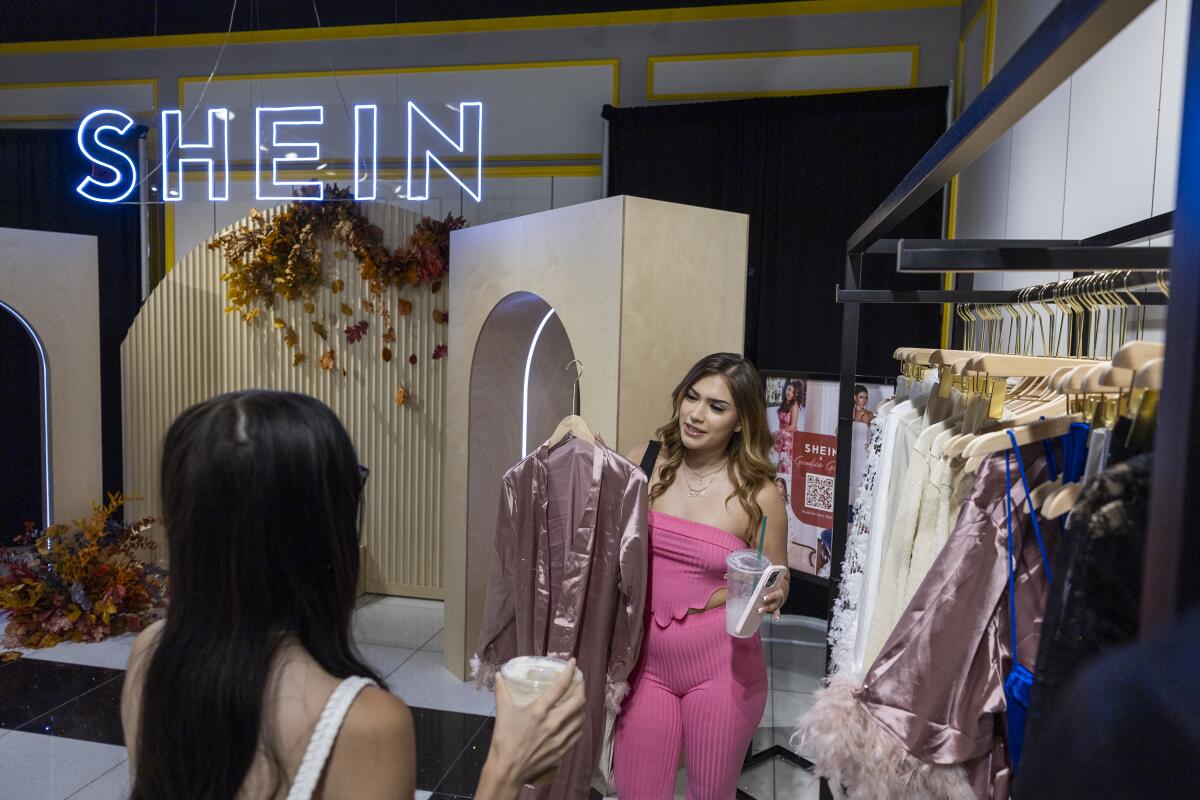 Two shoppers look at clothes