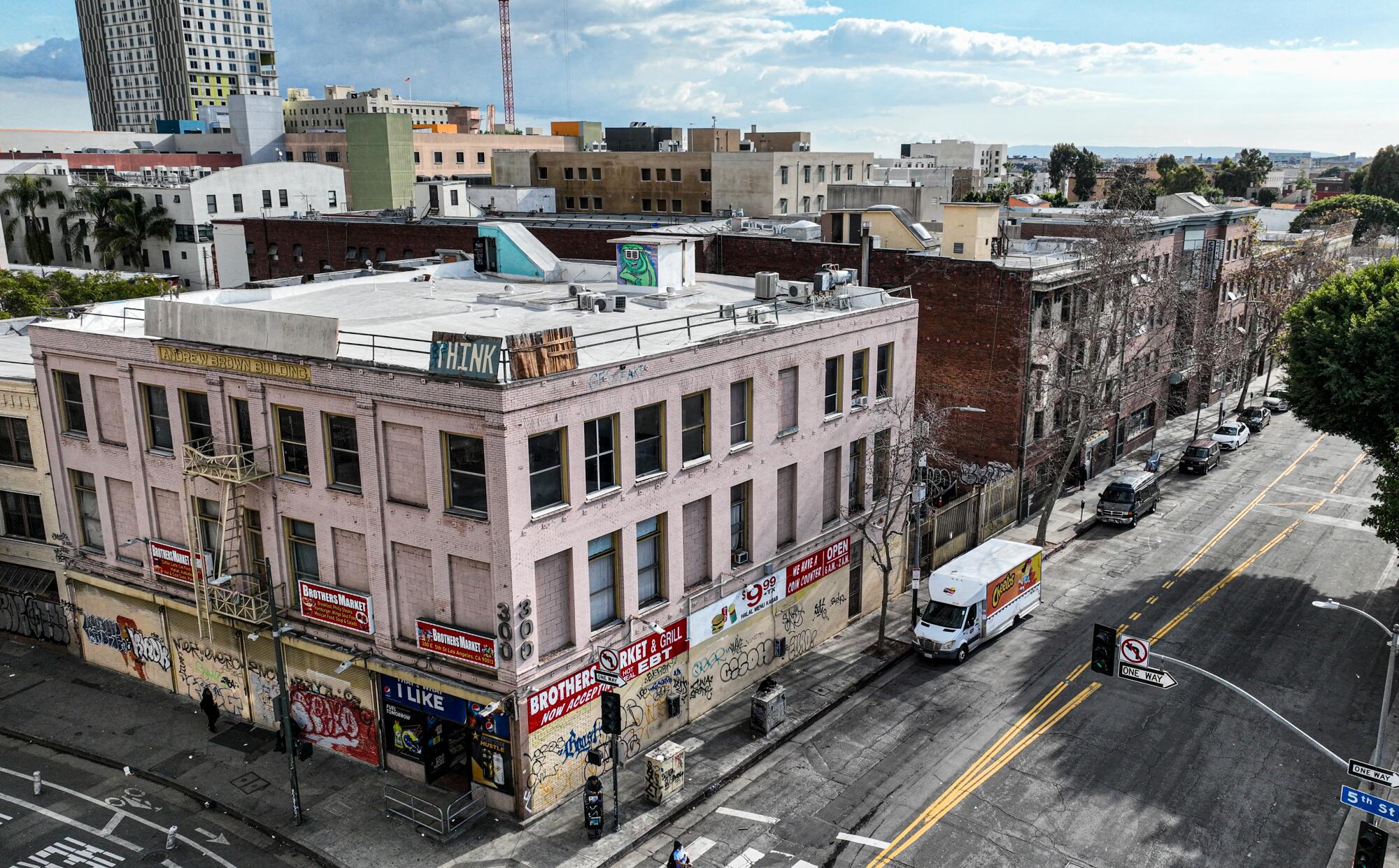 A view of Wall Street from Fifth Street, where a row of SRO Housing Corp. buildings stand.