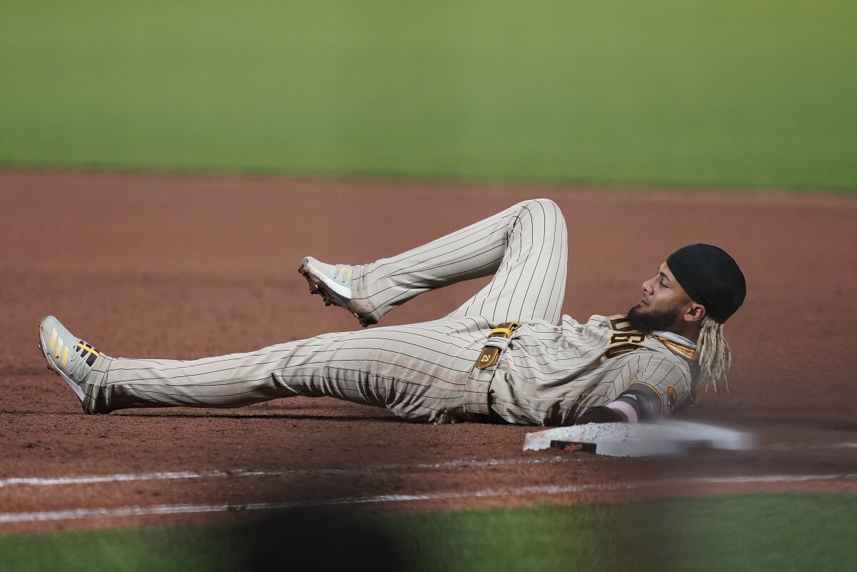 Fernando Tatis Jr. lies on the ground after being picked off at first base 