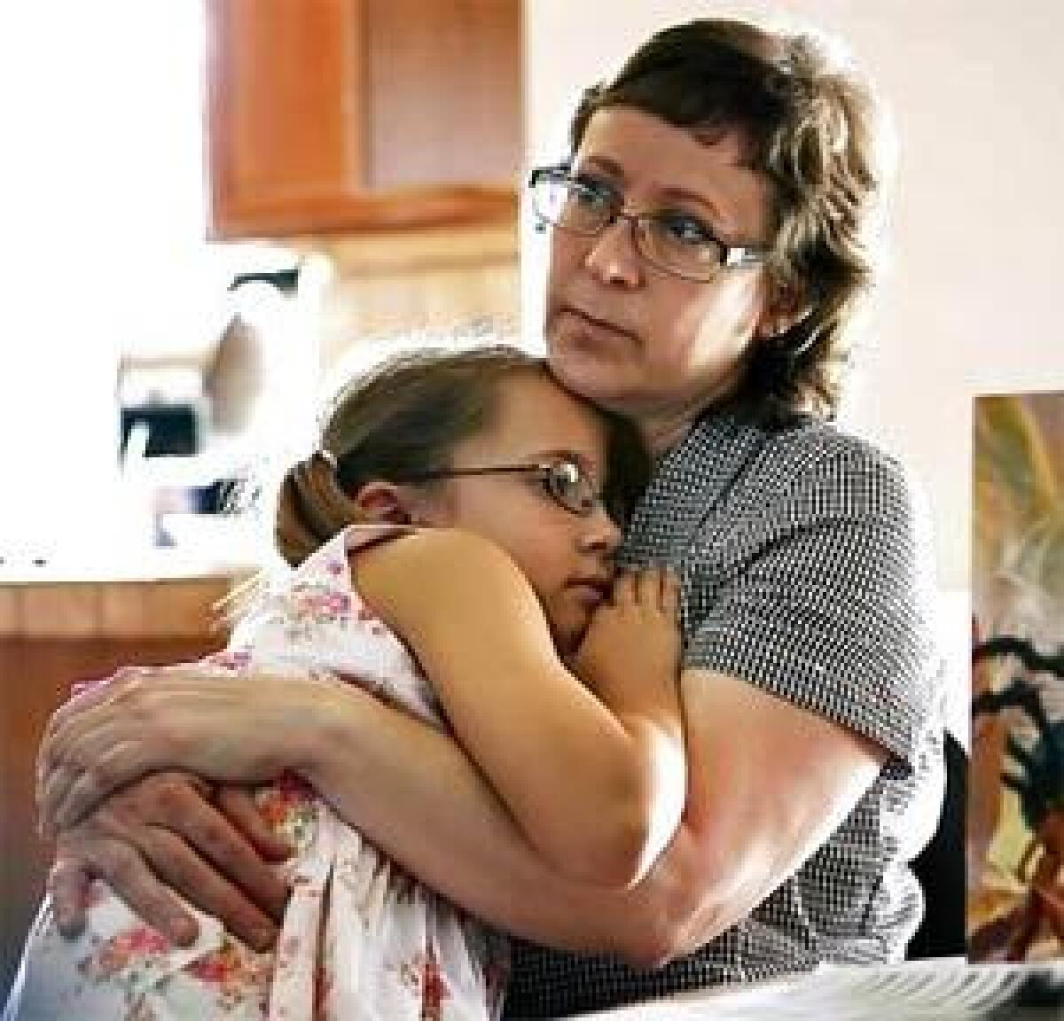 Leslie Udvardi snuggles with her daughter, Esther, as the family plays board games in July 2007. Esther and her three brothers were taken from Leslie and her husband, Kirk, after she was accused of having Munchausen syndrome by proxy in December 2005.