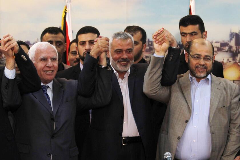 Palestinian Fatah delegation chief Azzam Ahmed, left, Hamas Prime Minister in the Gaza Strip Ismail Haniya and Hamas deputy leader Musa abu Marzuk pose for a photo as they celebrate the Palestinian unity accord Wednesday in Gaza City.