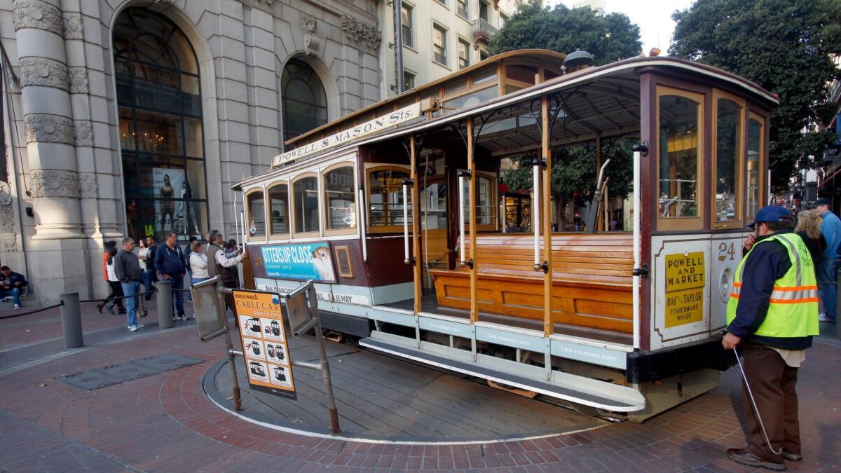 A San Francisco cable car is turned around by hand at Powell and Market streets. Four airlines are offering round-trip tickets from LAX to the City by the Bay for less than $100.