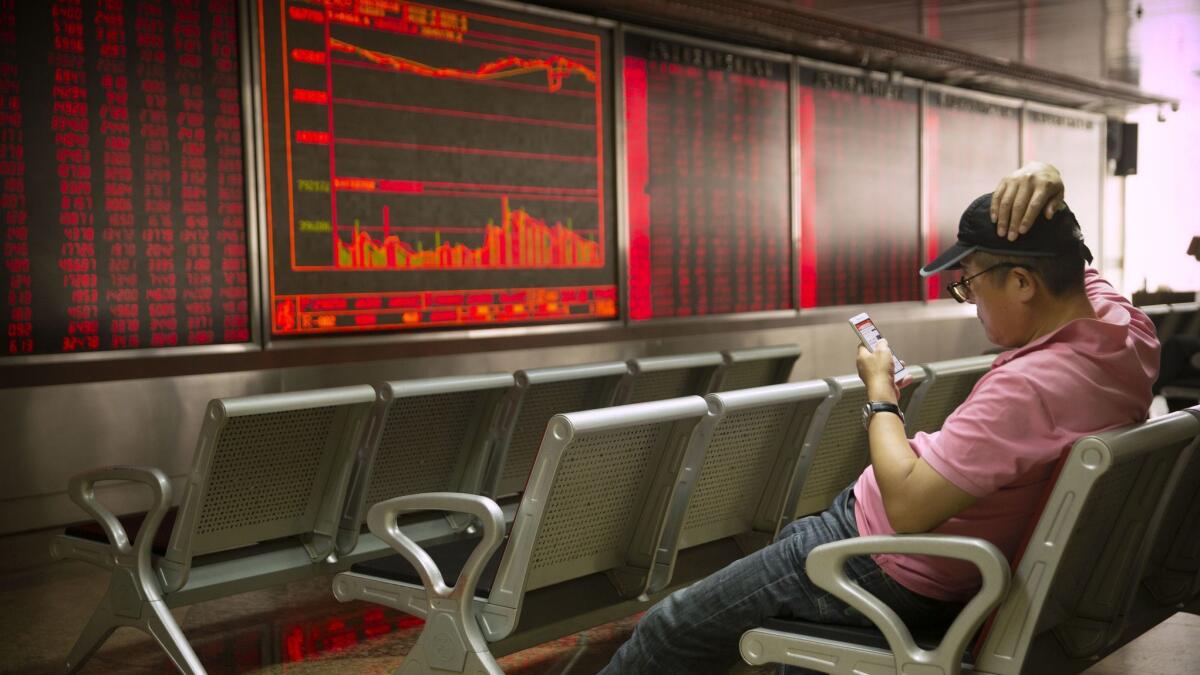 A Chinese investor monitors stock prices at a brokerage house in Beijing on Friday.